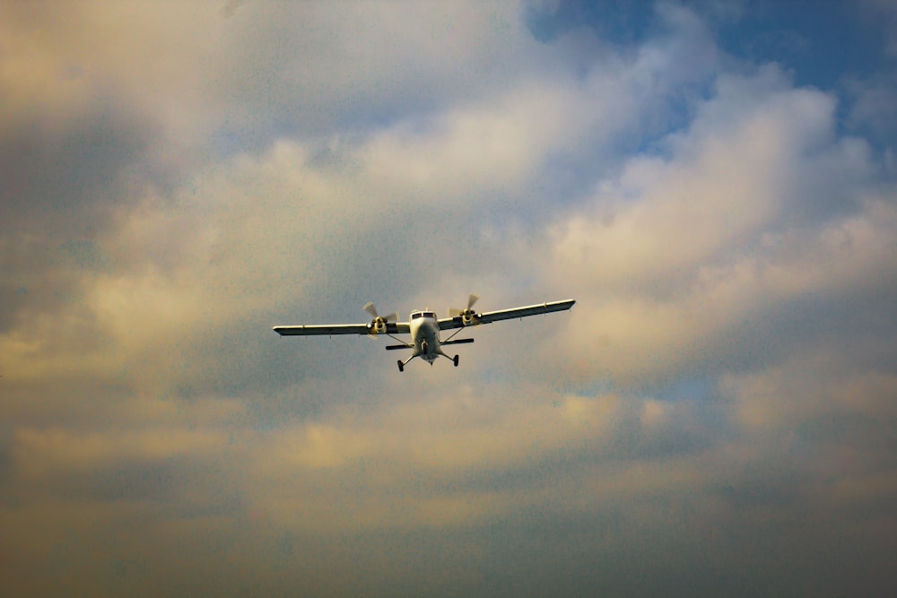 a small airplane flying through a cloudy sky