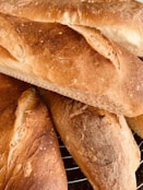 Freshly baked gluten-free bread cooling on a wooden rack.
