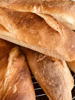 Freshly baked gluten-free braided breads cooling on a kitchen rack