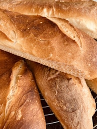 Freshly baked bread cooling on a wooden rack.
