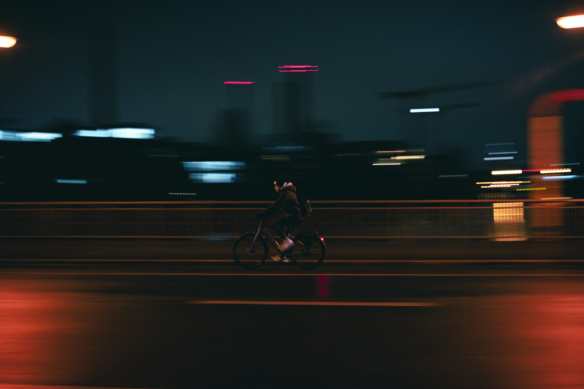a man riding a bike down a street at night