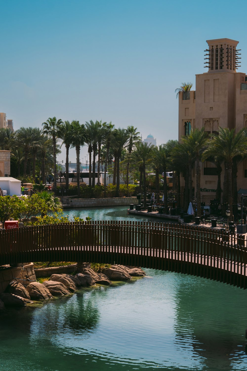 a bridge over a body of water with palm trees in the background