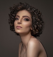 a woman with curly hair wearing a black dress