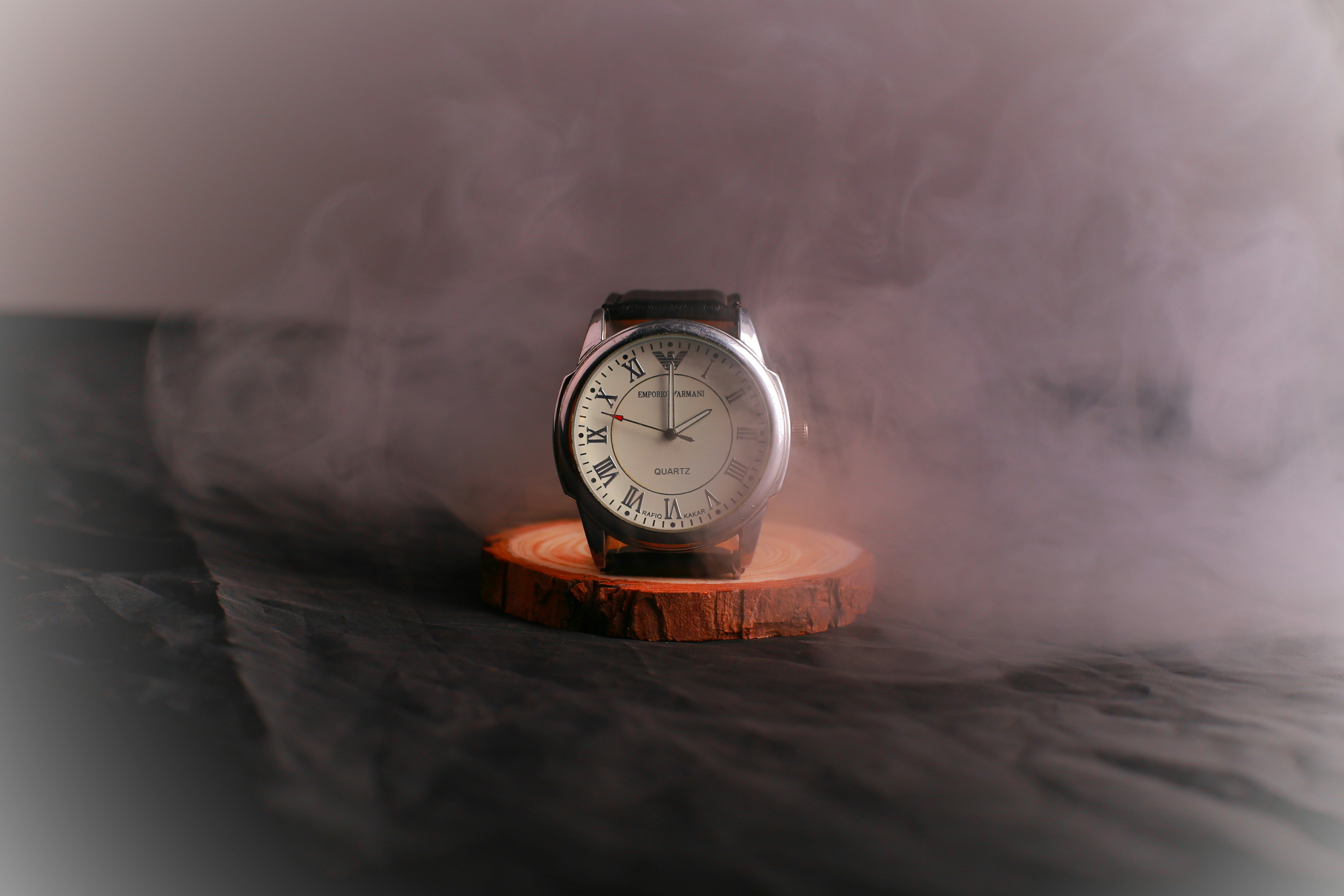 Un reloj sentado encima de un soporte de madera