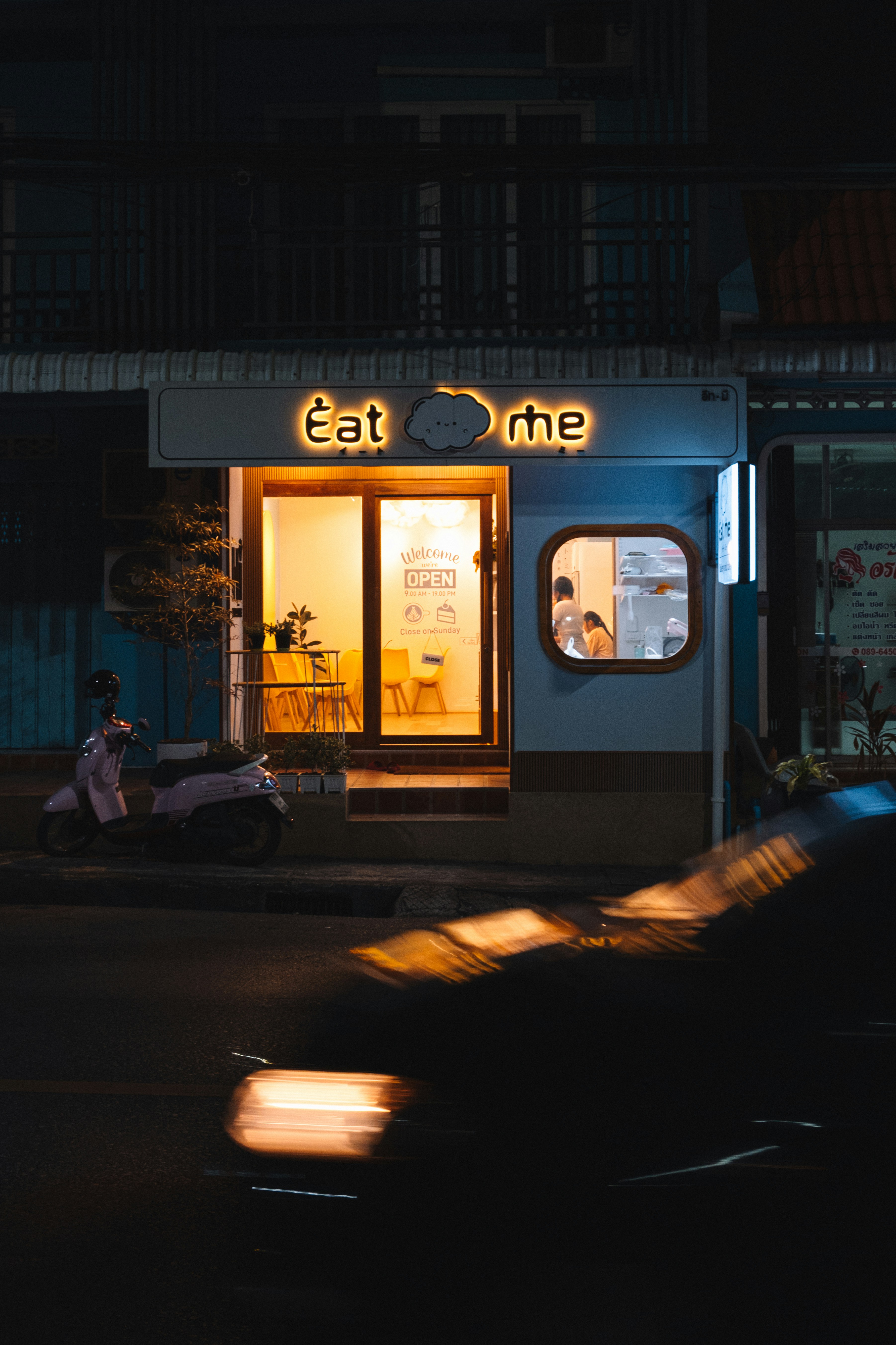 a car driving past a restaurant at night