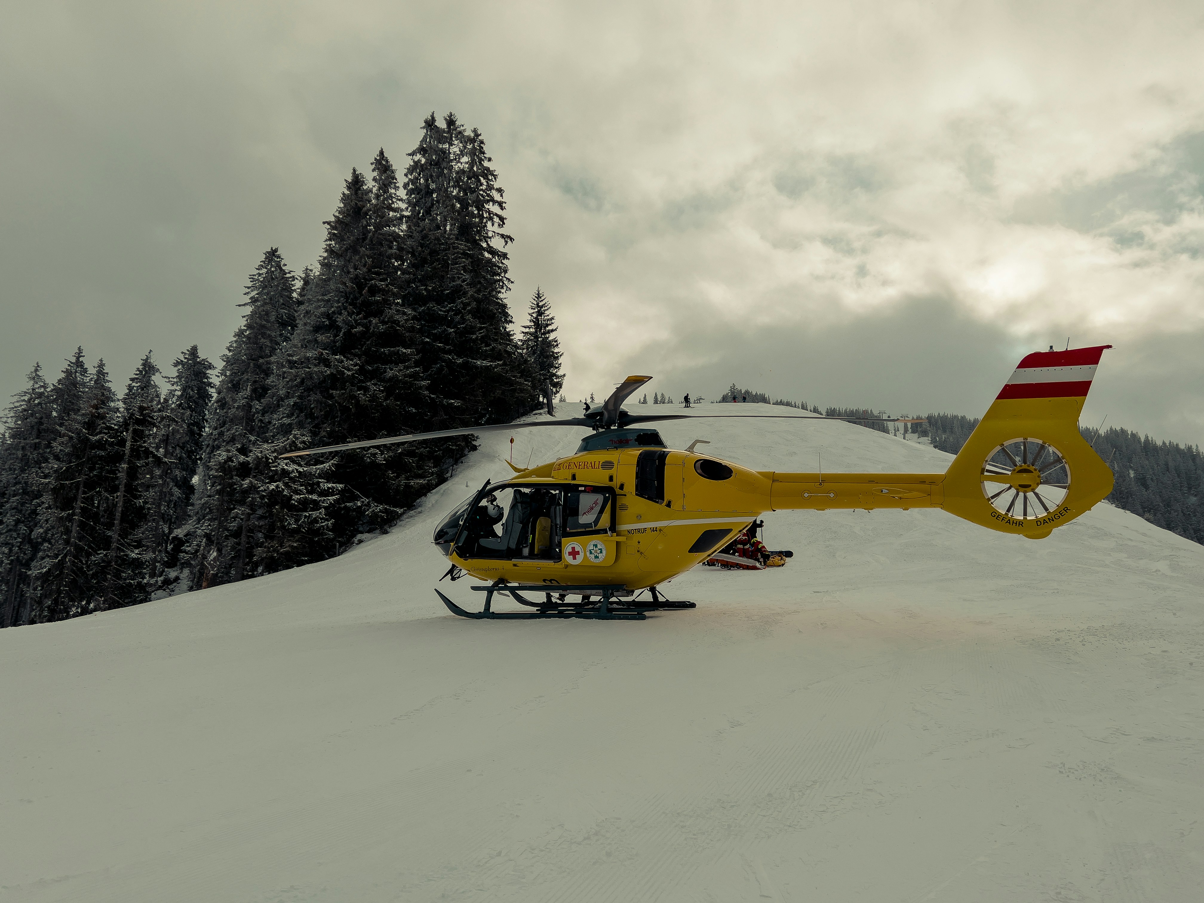 a helicopter sitting on top of a snow covered slope