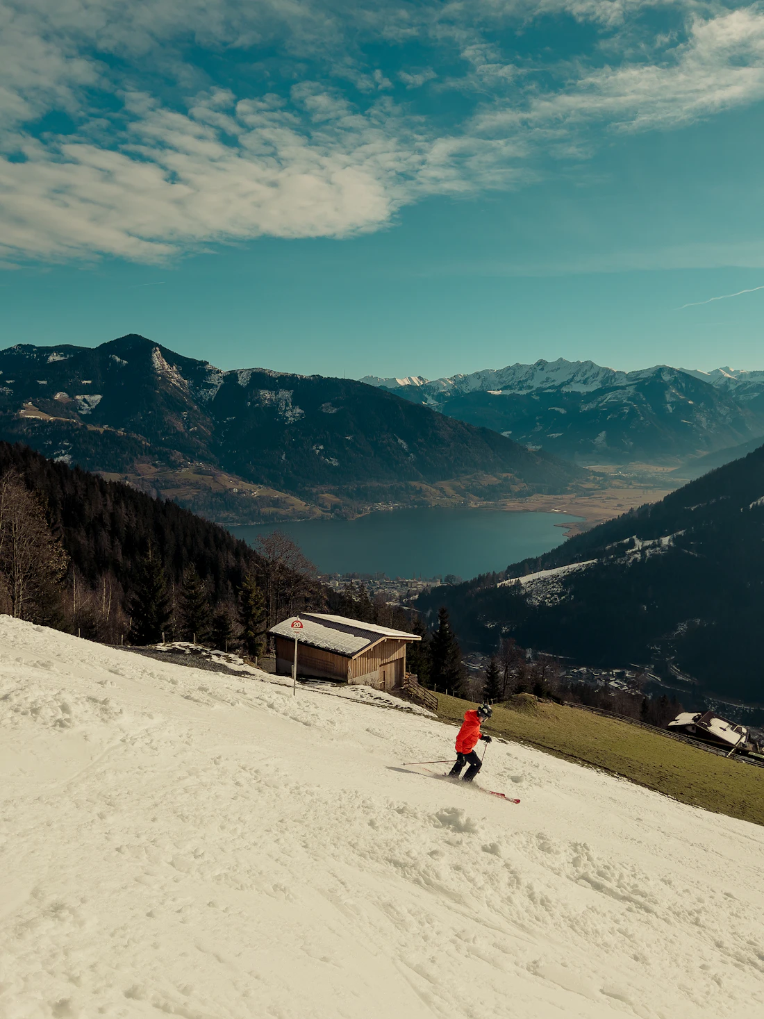 Skiër op een besneeuwde helling boven Zell am See