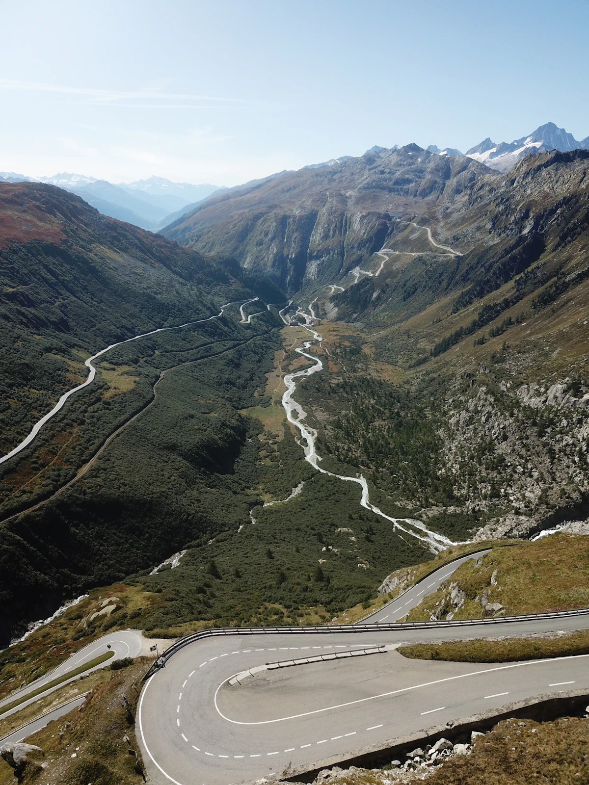 Tornante di un passo alpino svizzero con la valle e i ghiacciai sullo sfondo