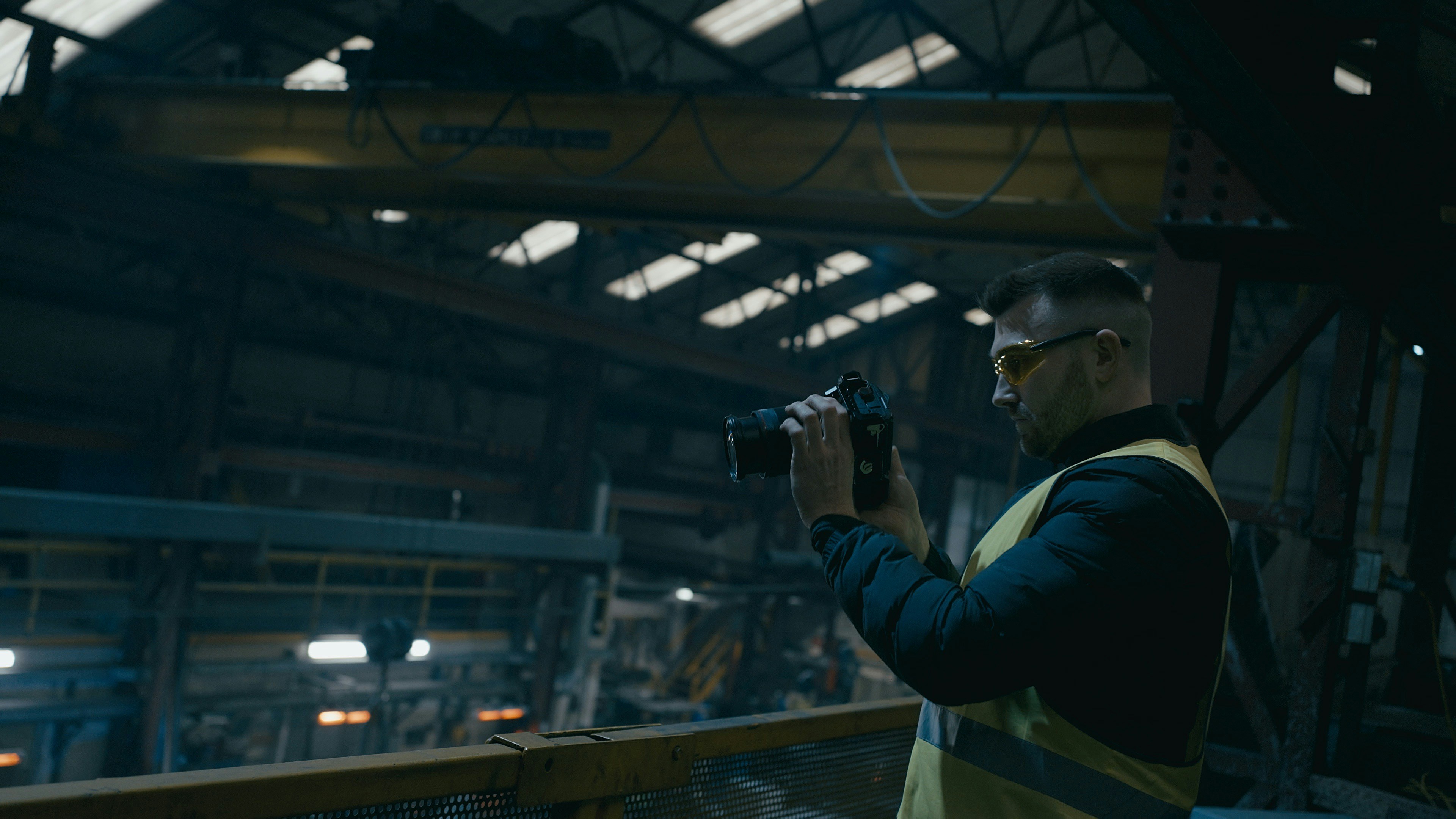 Manufacturing plant floor with a new operator standing at an assembly line, looking confused at a machine error code while an AI coach screen displays a standard procedure that doesn