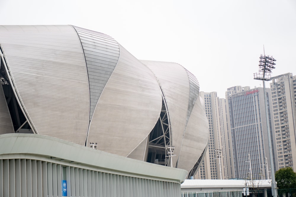 a large building with a curved roof in the middle of a city