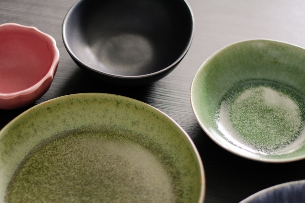 a table topped with three bowls of different colors