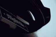 A close-up of a vehicle with a sticker reading 'Nightride' with stylized fonts and possibly Japanese characters above it. The image is dark and the exact part of the vehicle is not clearly visible.