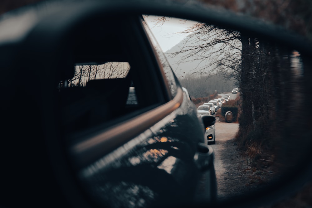 a rear view mirror reflecting a line of parked cars