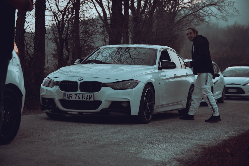 a man walking next to a white car