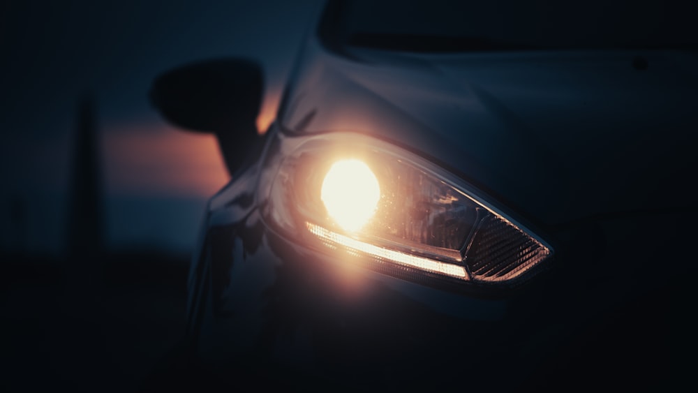 a close up of a car's headlight in the dark