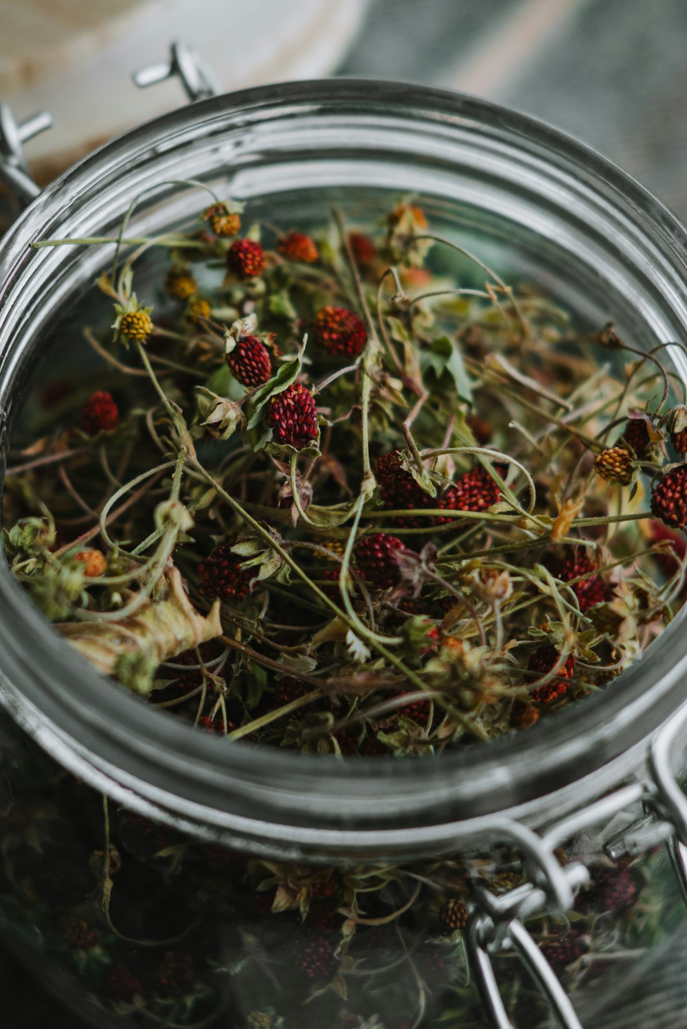 a glass jar filled with wild flowers on top of a table