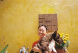 A smiling Moroccan pet owner holding their happy dog inside the veterinary clinic.