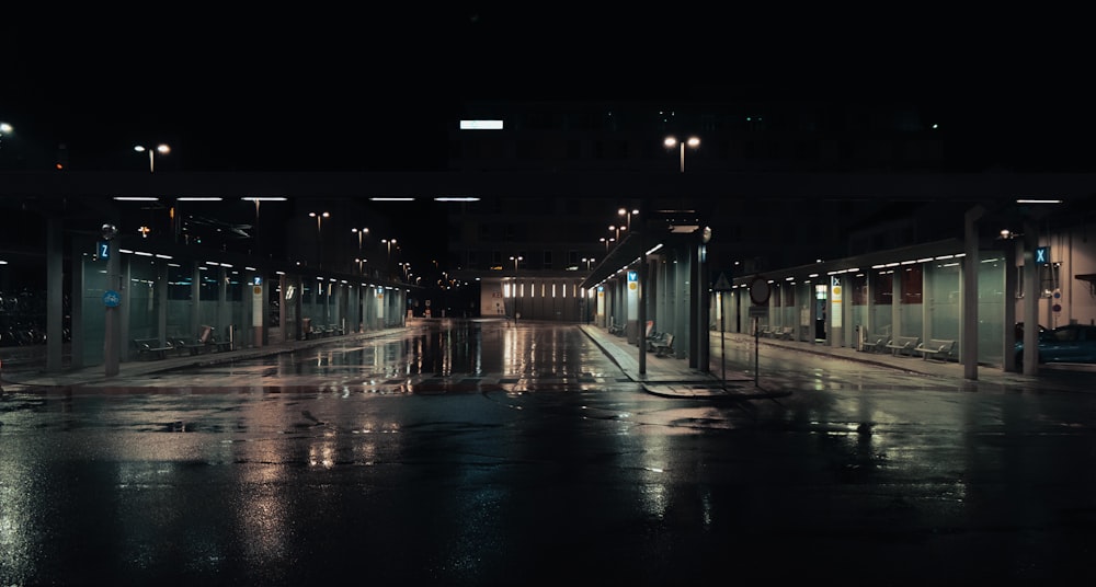 Una calle húmeda de la ciudad por la noche con las luces encendidas