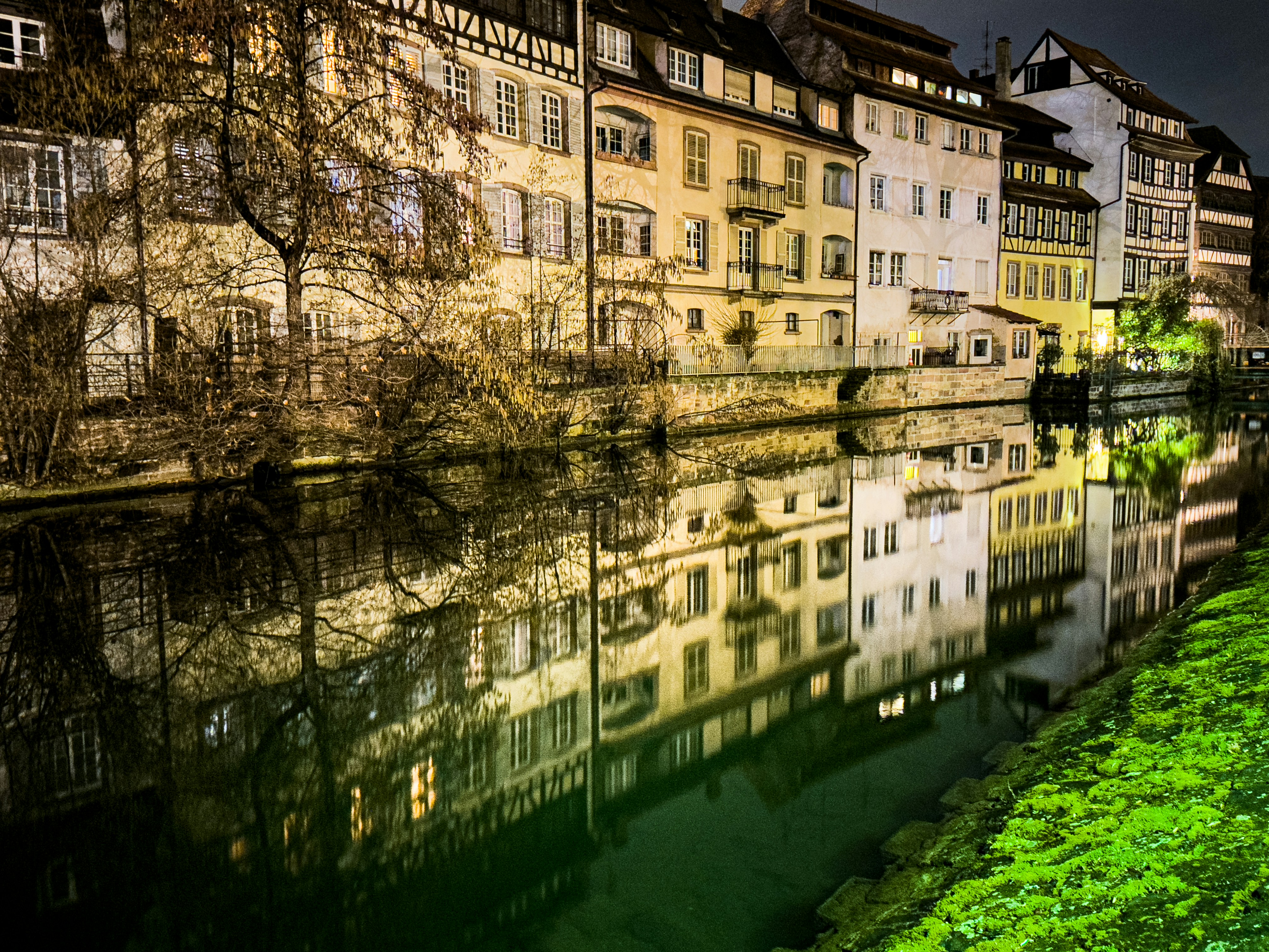 Une rivière qui traverse une ville à côté de grands immeubles photo Photo Strasbourg Gratuite