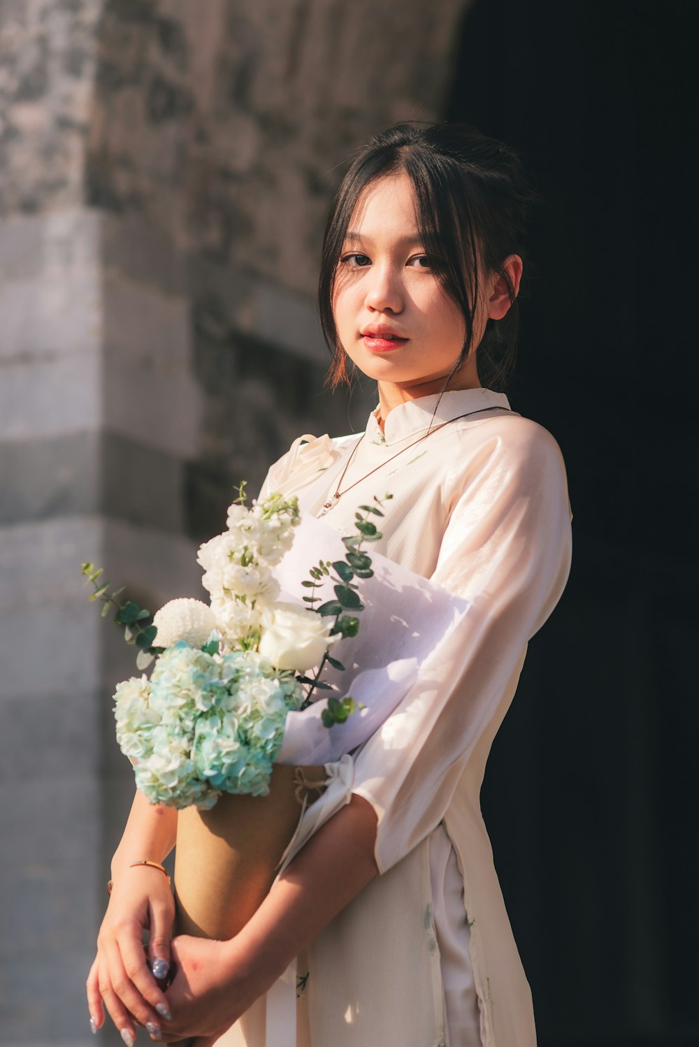 a woman in a white dress holding a bouquet of flowers