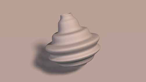 A smooth, sculptural object with a spiral or layered design, resembling a modern art piece or a decorative vase, is placed against a neutral background. The object appears to be made of a material like ceramic or metal.