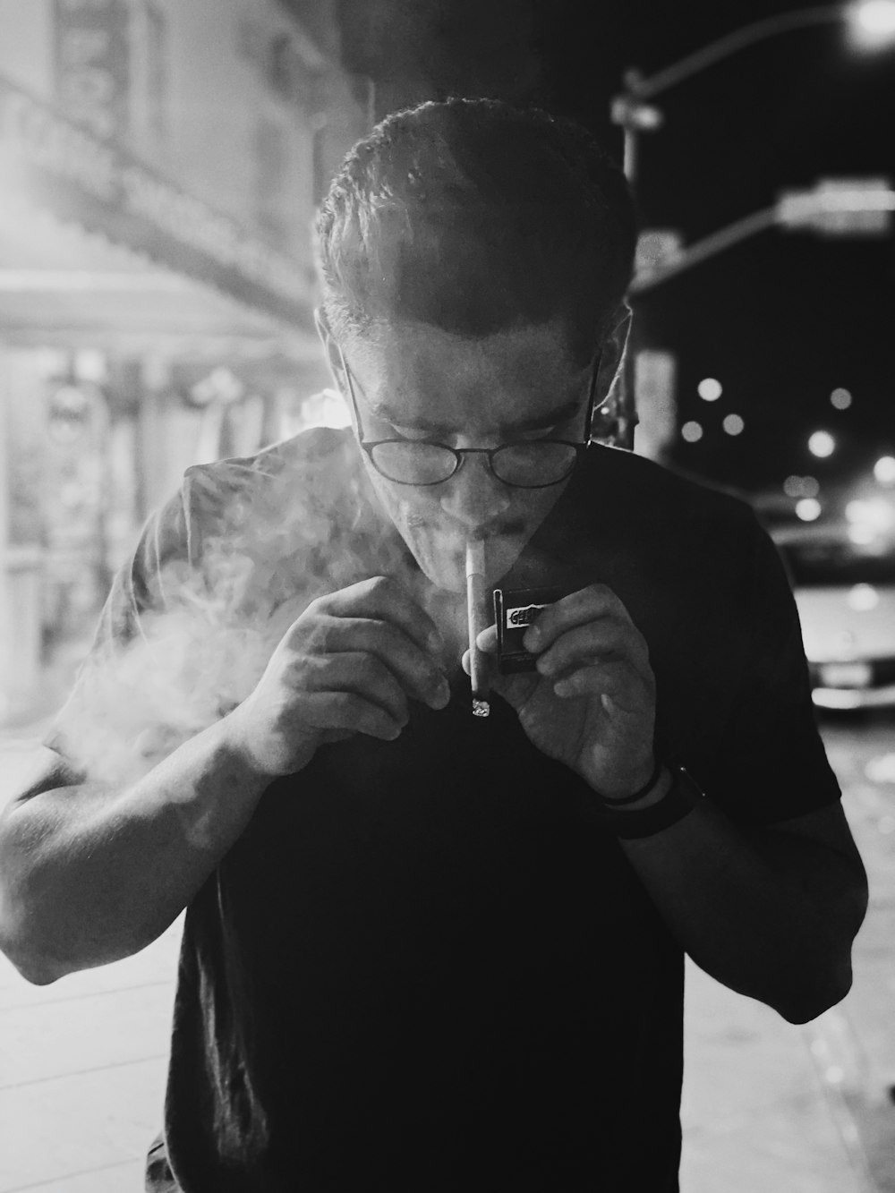 a man smoking a cigarette on a city street