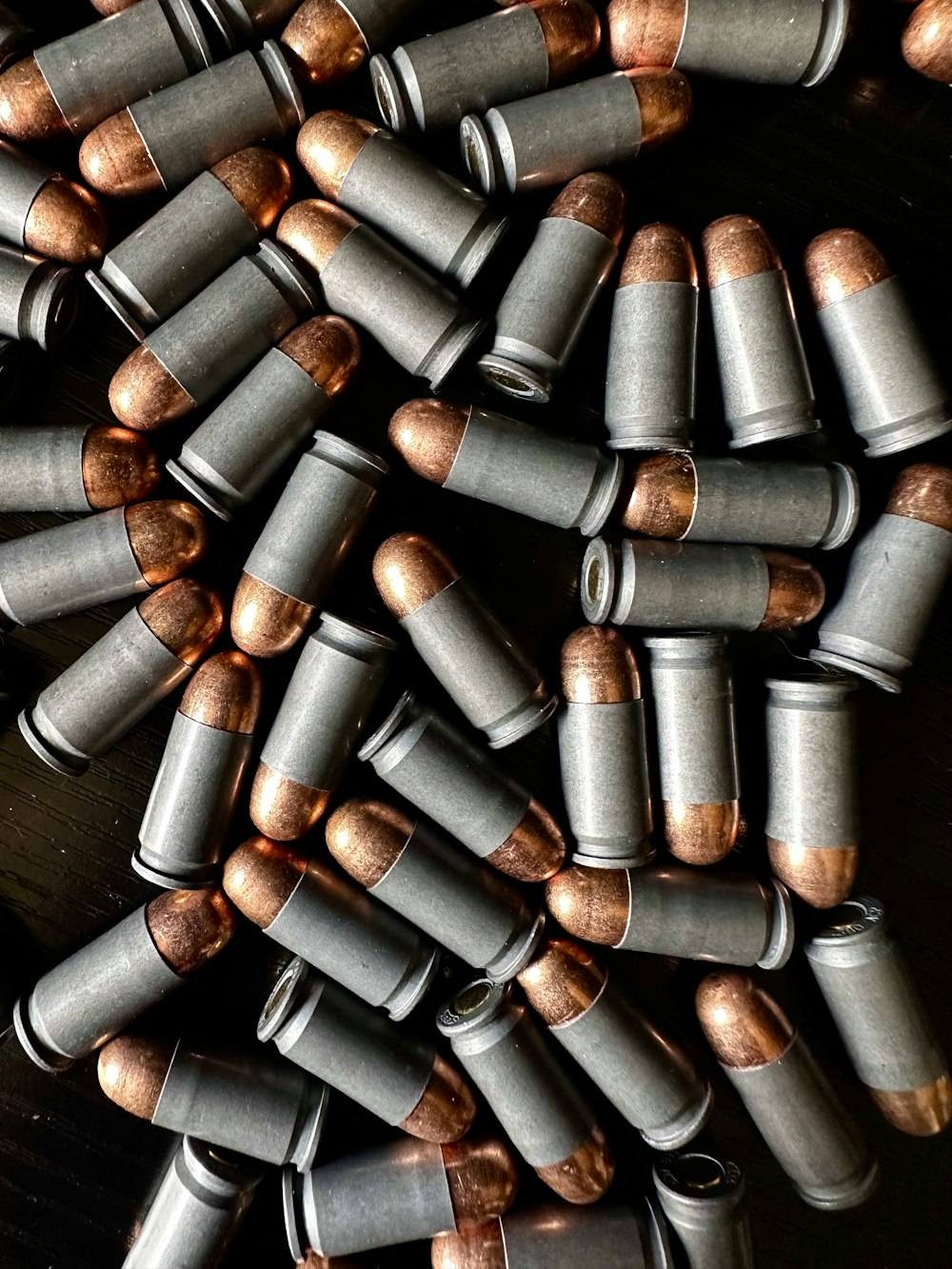 a bunch of silver and copper bullet shells