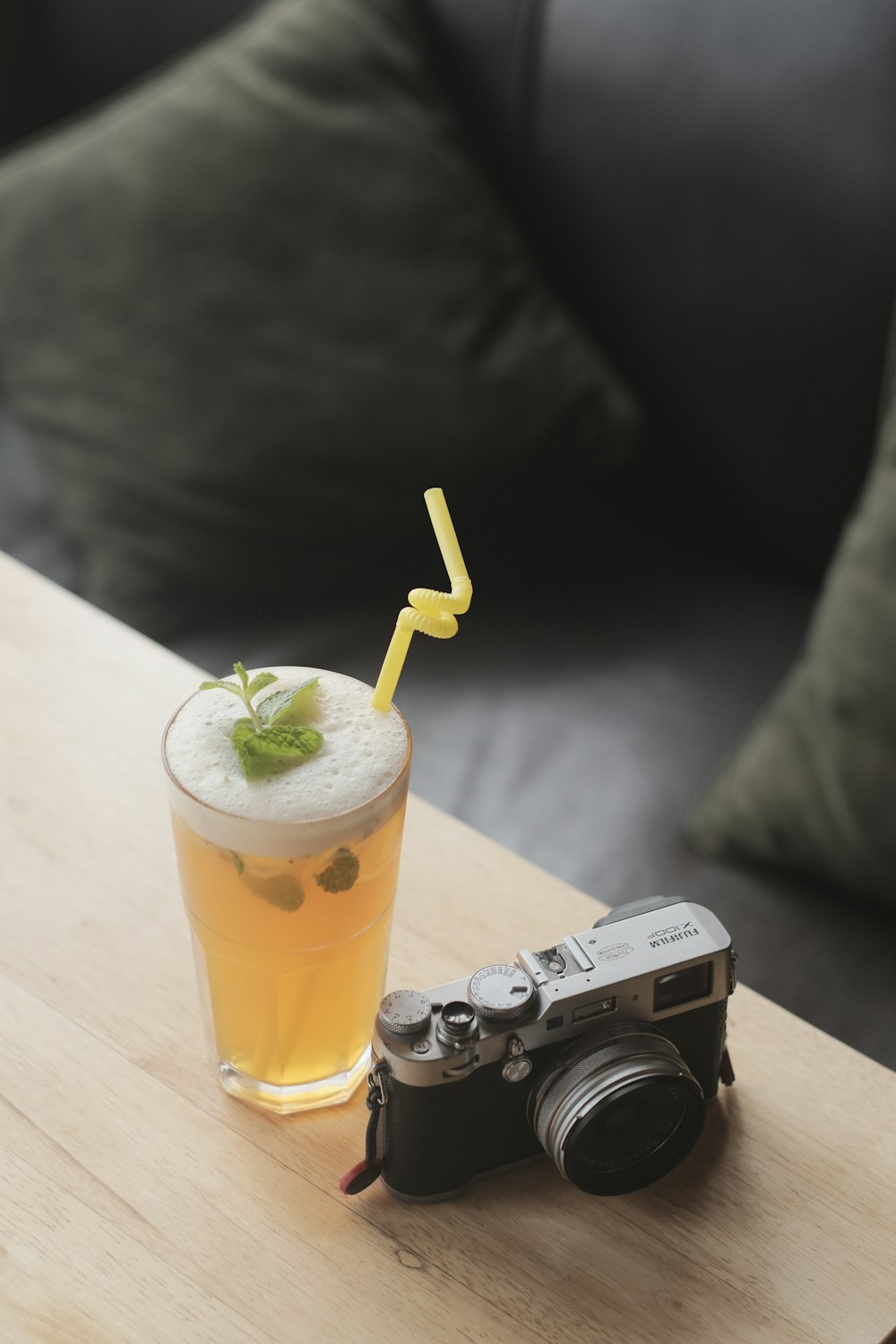 a camera and a drink on a table