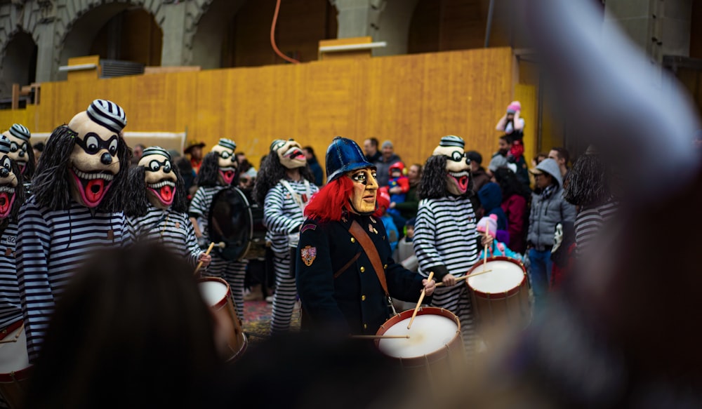 a group of people with painted faces and body paint playing drums
