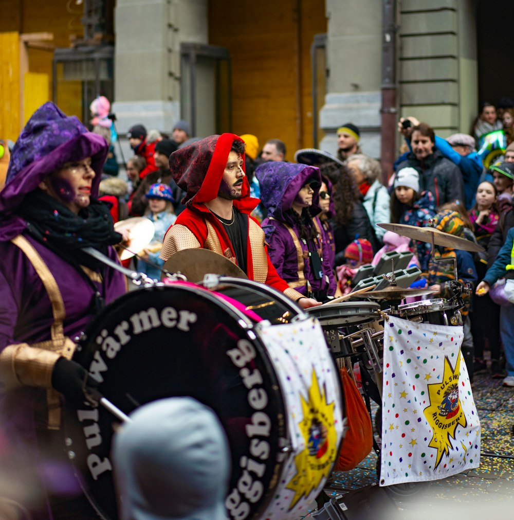 a group of people dressed in costumes playing drums