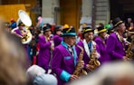 a group of men in purple suits and hats playing musical instruments
