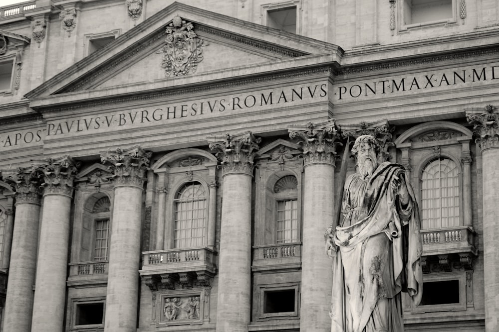 uma foto em preto e branco de uma estátua em frente a um edifício