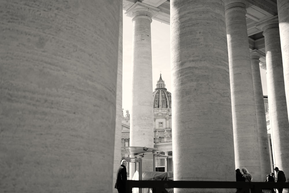 Una foto en blanco y negro de columnas y una torre del reloj