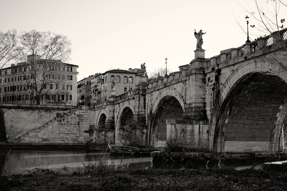 a black and white photo of a bridge and buildings