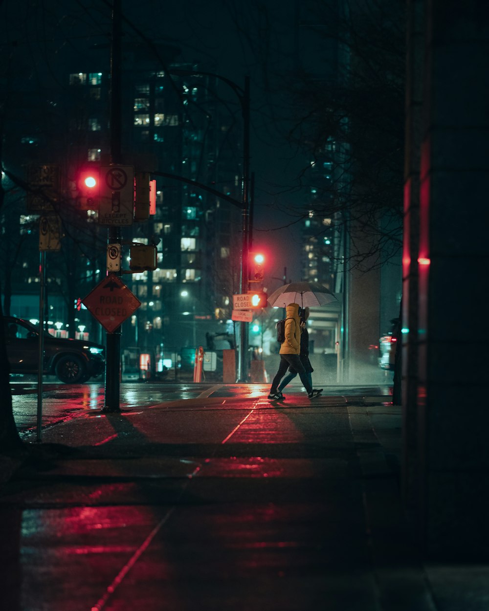 a person walking down a street at night with an umbrella