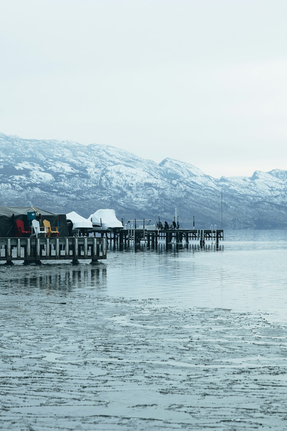 a pier with snow covered mountains in the background