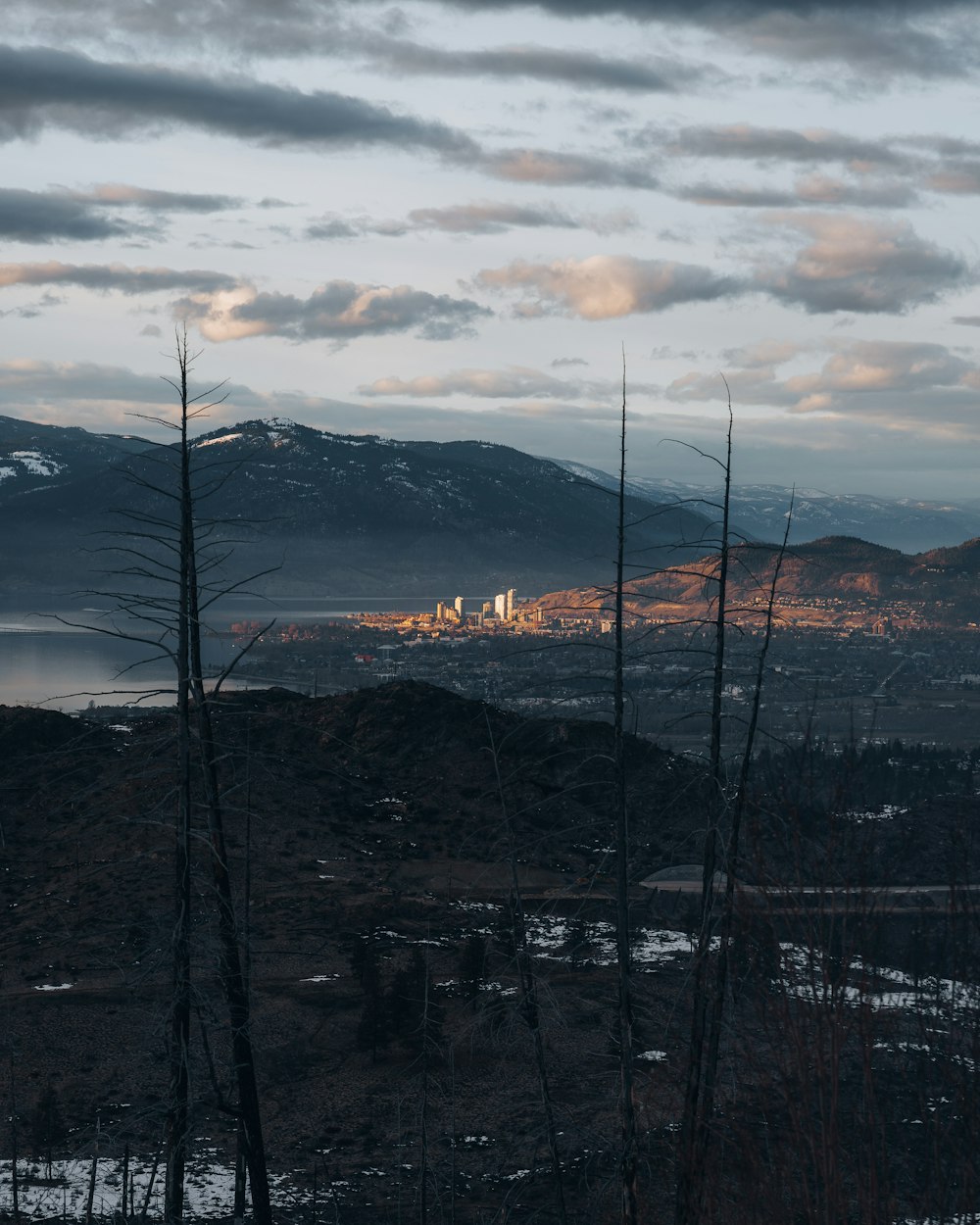 a view of a city in the distance with mountains in the background