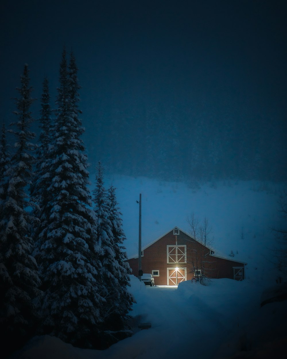 a barn in the middle of a snowy forest