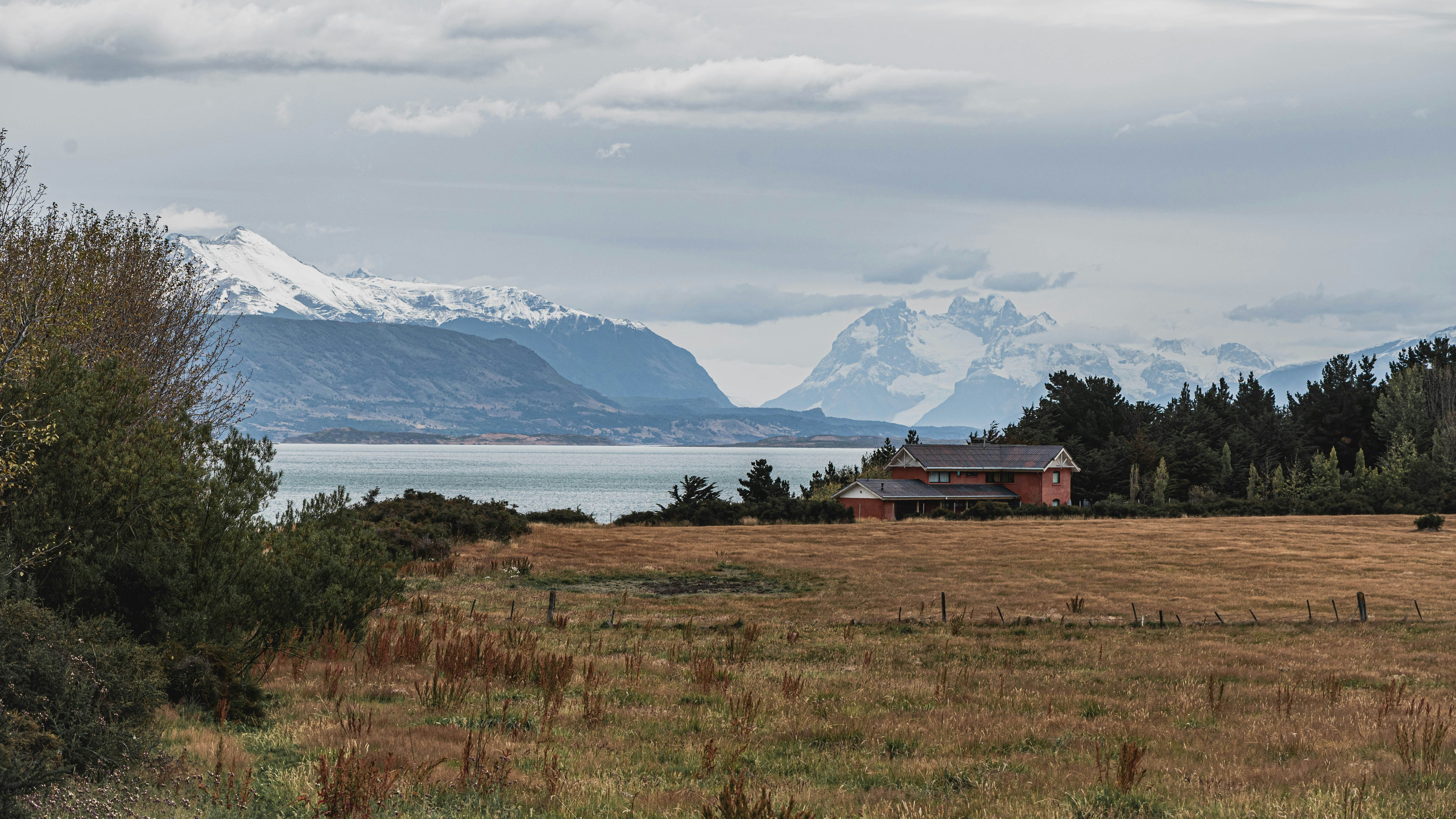 a house in a field with mountains in the background