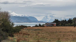 a house in a field with mountains in the background