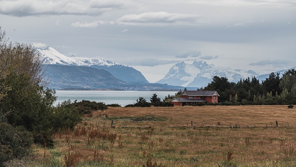 a house in a field with mountains in the background