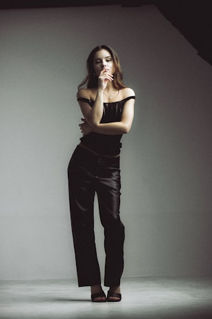 A confident woman wearing sleek, seamless shapewear in a softly lit, minimalist room.