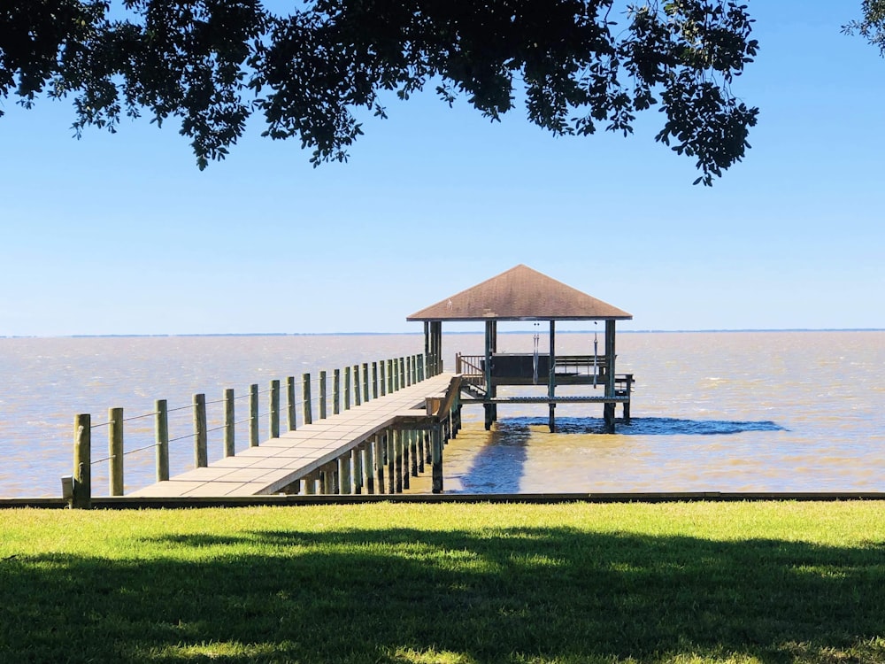 a wooden dock sitting on top of a lush green field