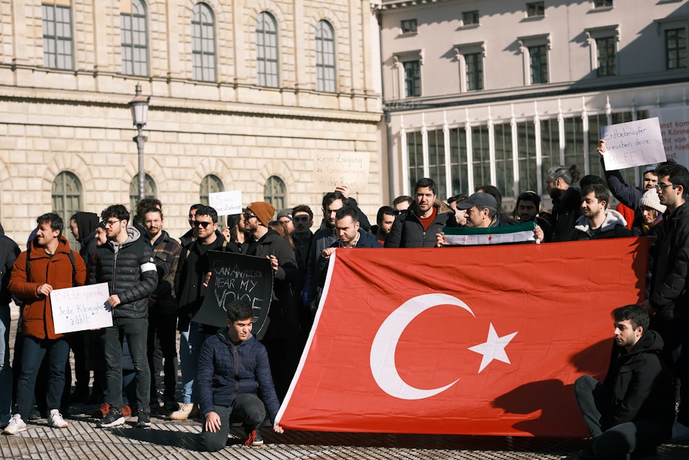a group of people holding a large turkey flag