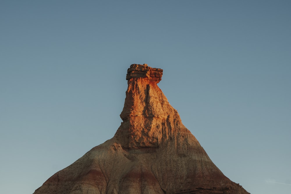 a tall rock formation with a sky background