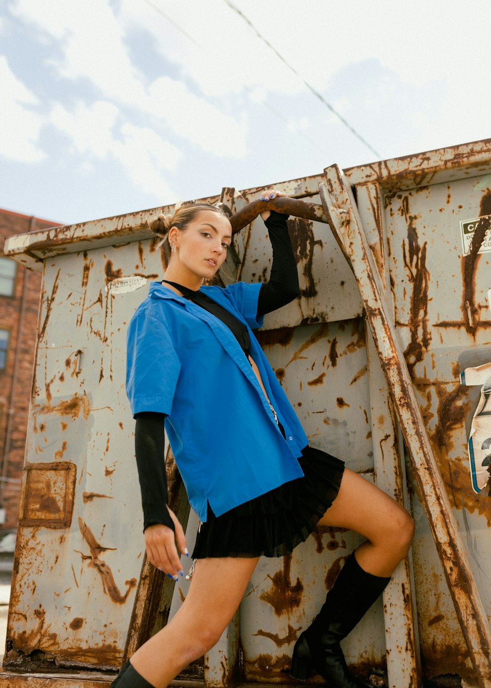 a woman posing in front of a rusted truck