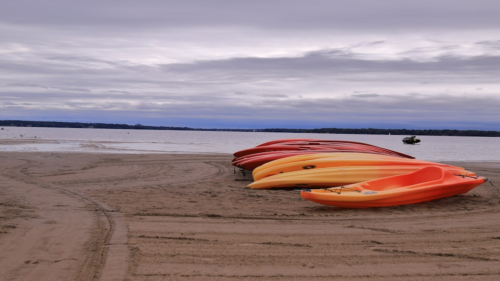 a row of canoes sitting on top of a sandy beach
