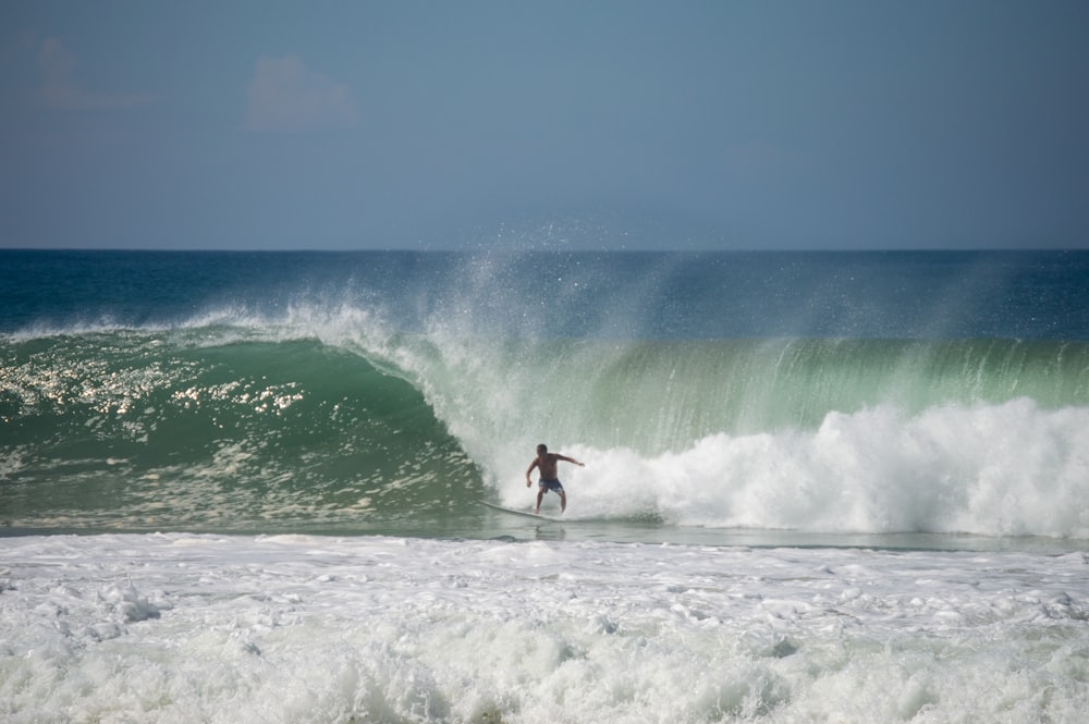 Ein Mann reitet auf einer Welle auf einem Surfbrett