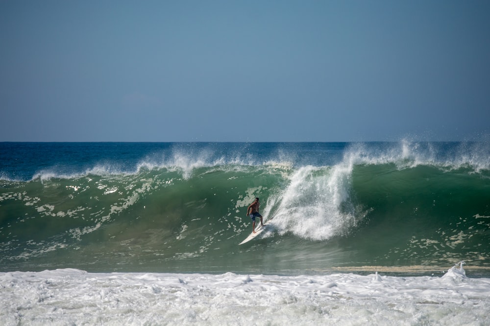 Ein Mann reitet auf einer Welle auf einem Surfbrett