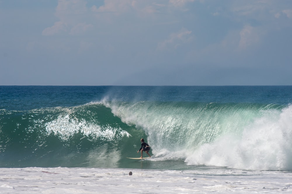 a man riding a wave on top of a surfboard